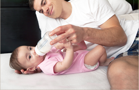 Dad feeding a baby