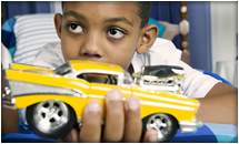 Preschool boy holding a toy car.