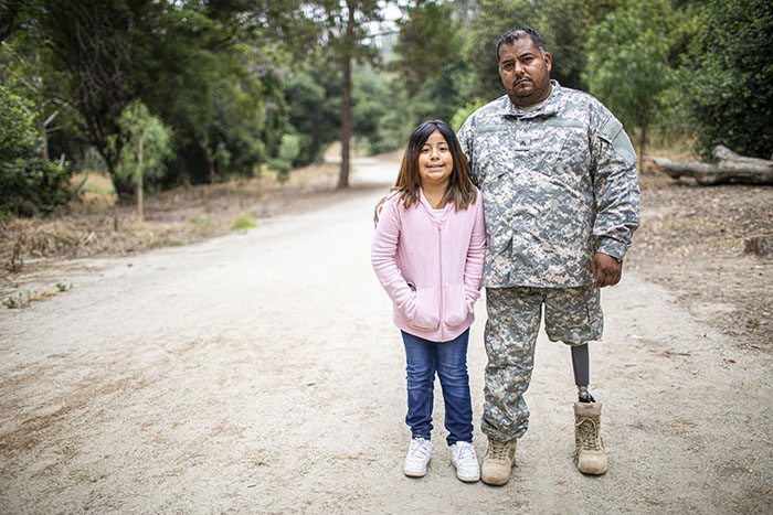 Image of a disabled soldier embracing his daughter