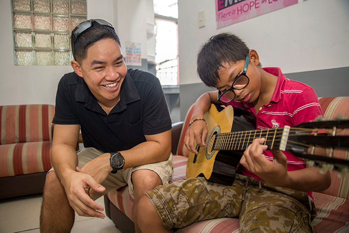 Father teaching son to play guitar