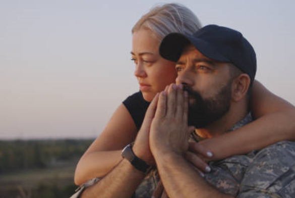Image of a wife embracing her husband who is looking worried.